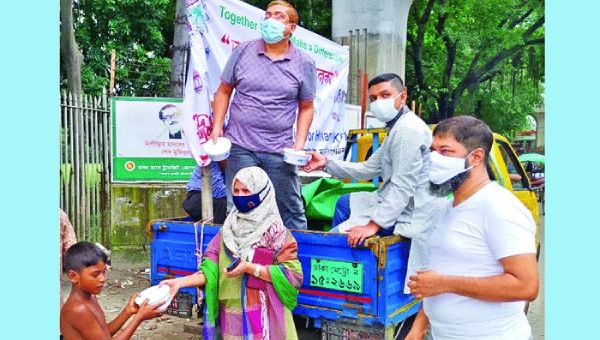 Members of Krishibid Foundation for Humanity distribute food packets among poor people in the old part of Dhaka on the Eid day on Wednesday